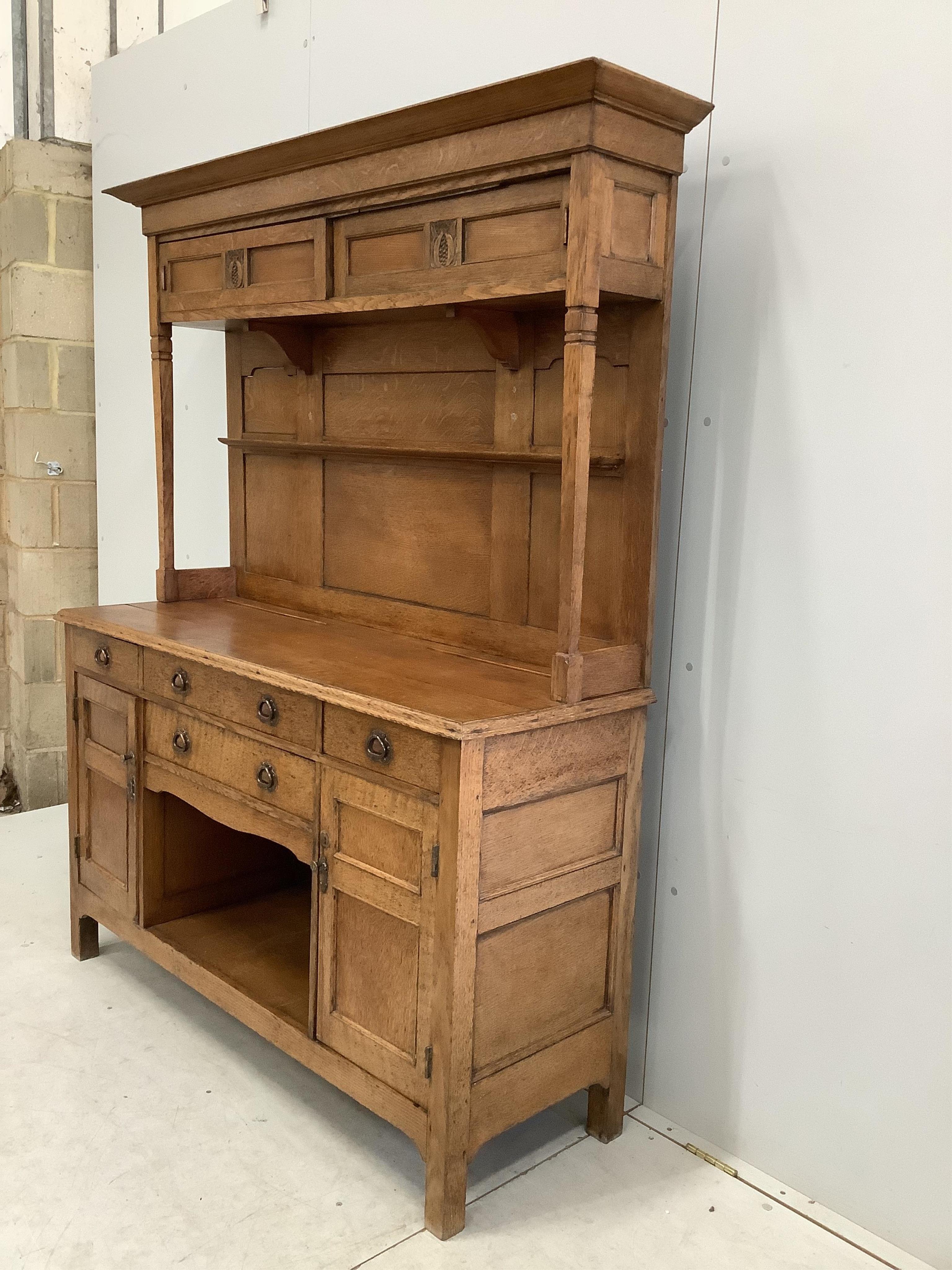 A small Arts & Crafts copper mounted oak dresser, width 140cm, depth 48cm, height 182cm. Condition - fair